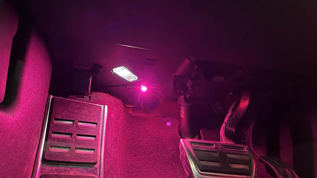 Audi A6 4G Fußraum mit pinkem RGB-Ambientelicht, OBD-Anschluss sichtbar